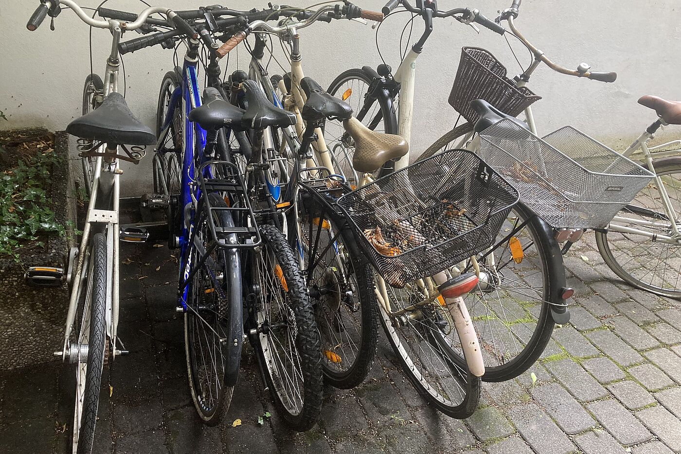 rraeder stehen zusammen gequetscht im Regen da kein Fahrradraum vorhanden ist.