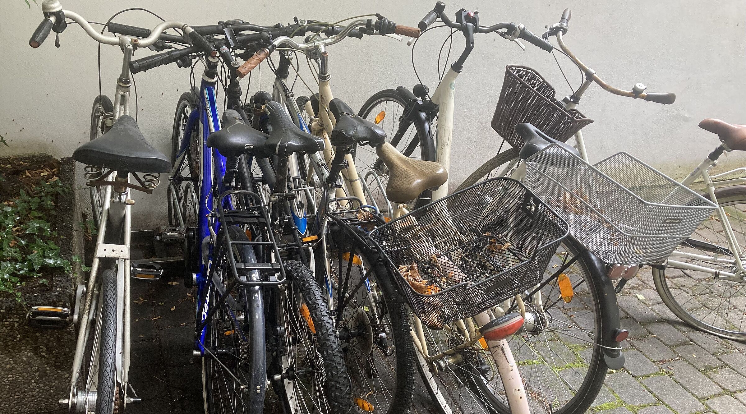 rraeder stehen zusammen gequetscht im Regen da kein Fahrradraum vorhanden ist.